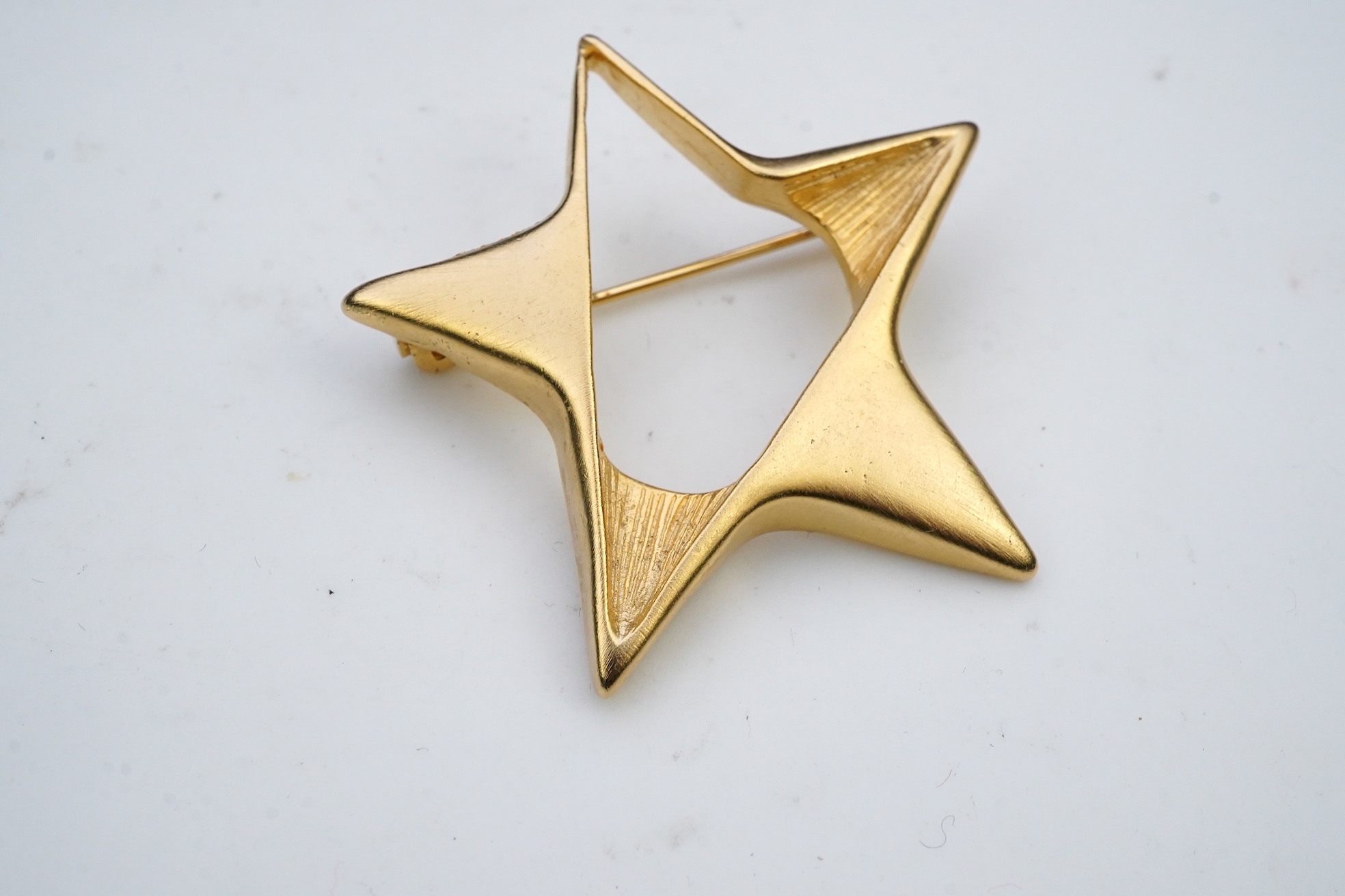 A tarnished gold star brooch in box